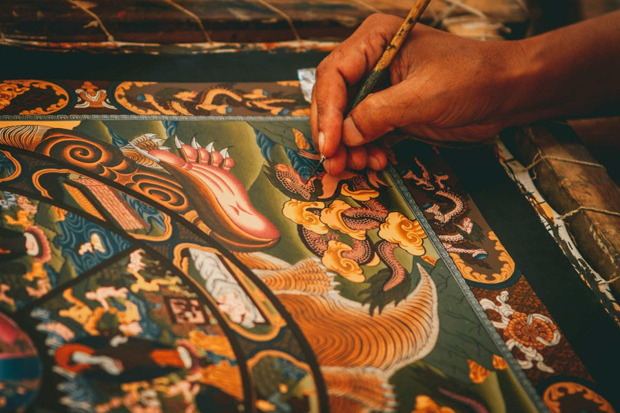 Tibetan thangka art being painted with detailed craftsmanship.