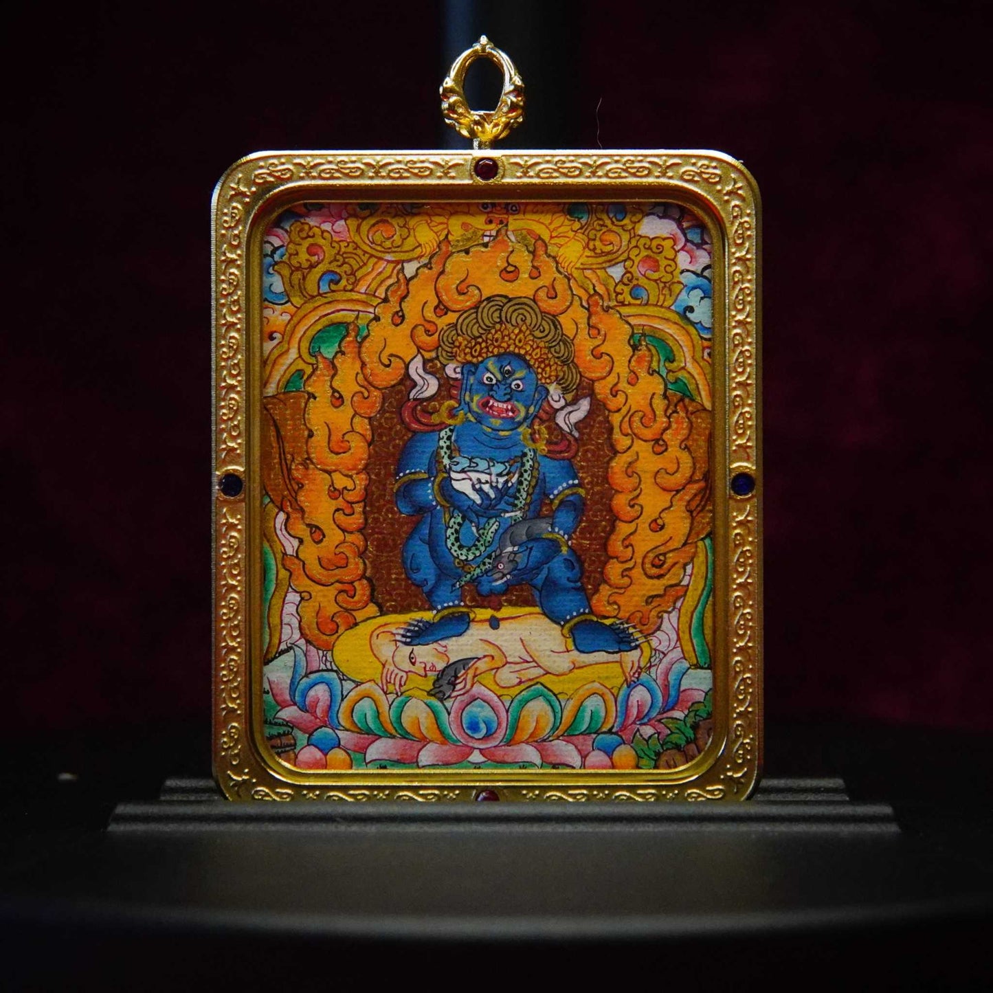 Black Jambhala Tibetan Thangka Pendant with ornate golden frame, depicting wealth deity for prosperity and protection.