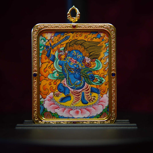 Handcrafted Acala Buddha Necklace featuring a lapis blue thangka pendant depicting Acala, surrounded by purifying flames and detailed with a golden Dharmachakra halo, set in an antique bronze frame.