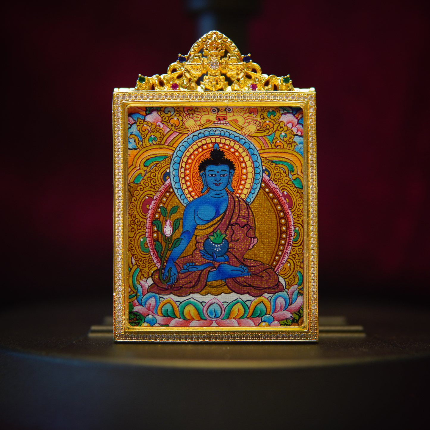 Medicine Buddha Healing Thangka Pendant featuring intricate artisan craftsmanship, celestial blue Bhaisajyaguru, and 24K gold-plated filigree.