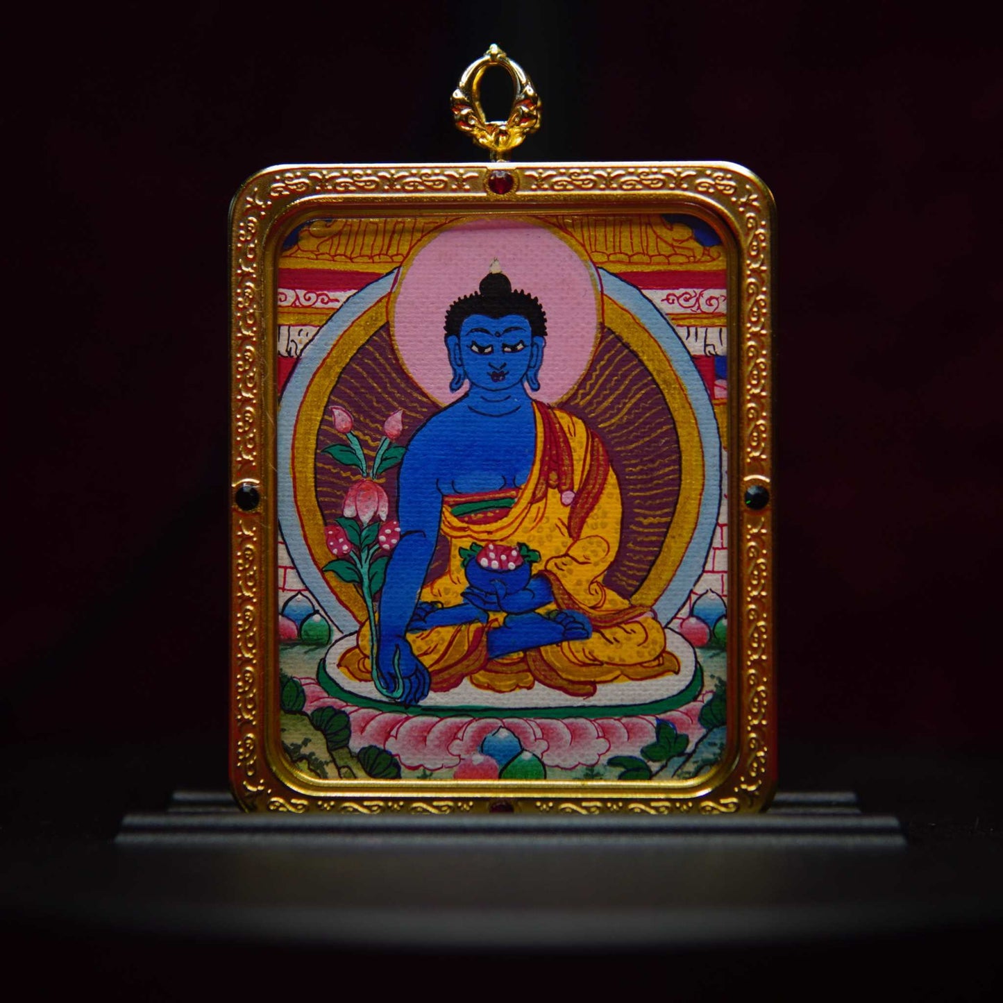 Hand-painted Tibetan Medicine Buddha Thangka necklace with sapphire blue depiction in antique gold frame, symbolizing spiritual healing.