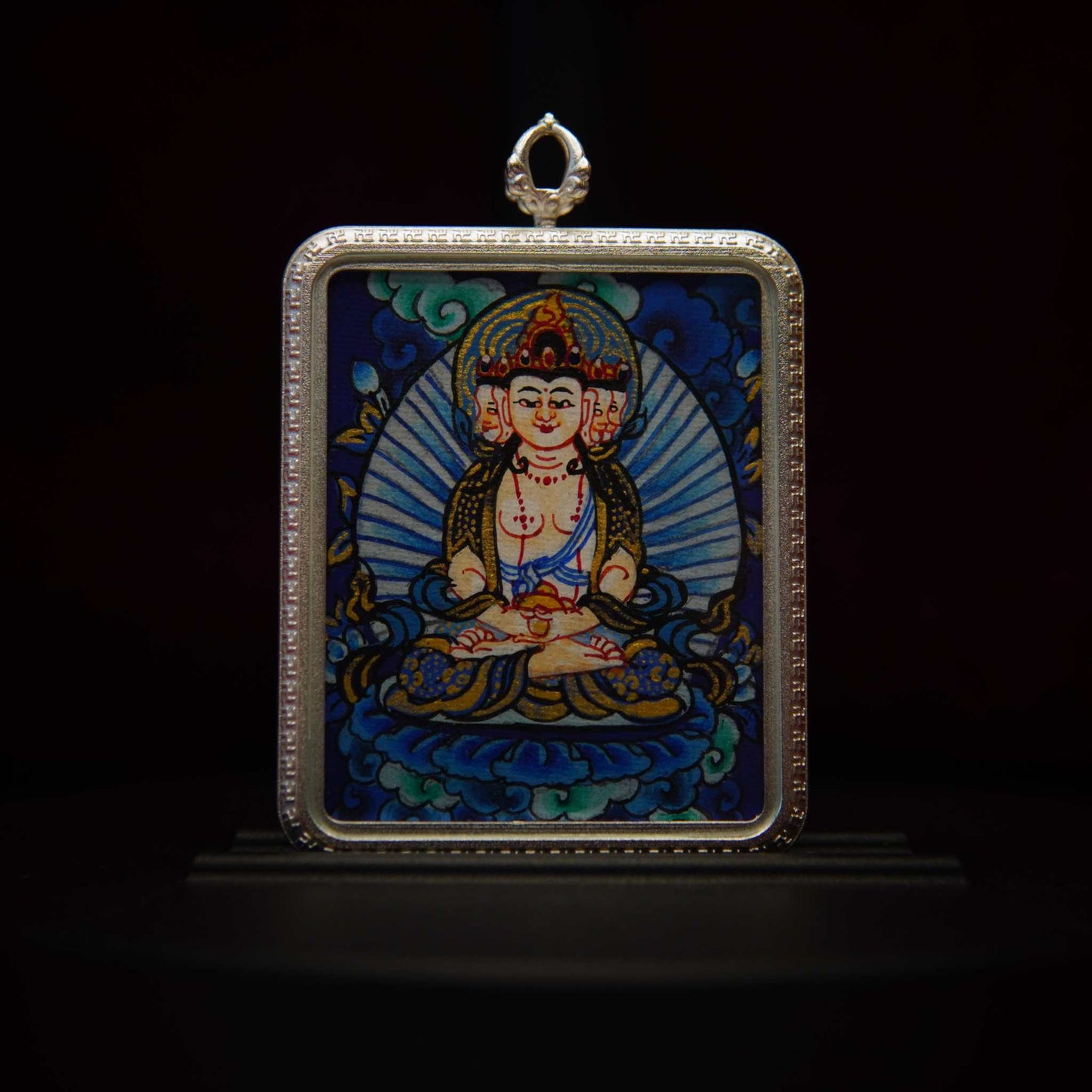Vairocana Buddha Thangka pendant with cosmic illumination design in antique silver frame.