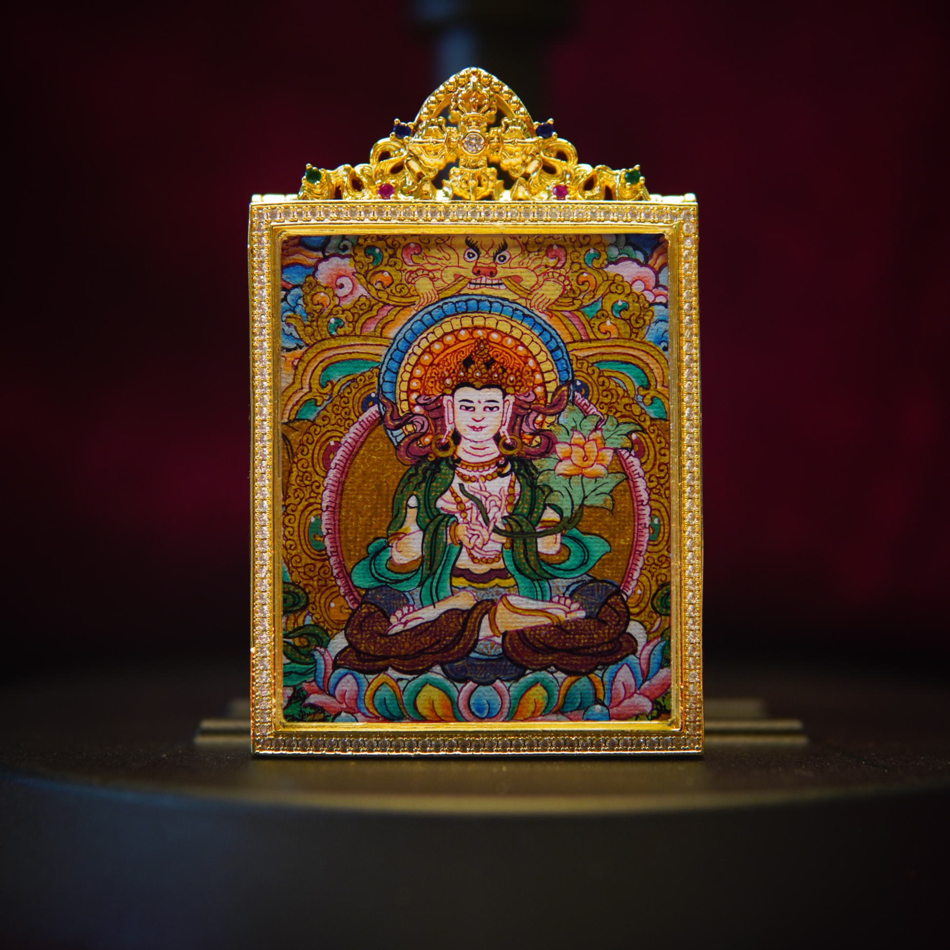 Hand-painted Vajra Wisdom Thangka pendant depicting Mahasthamaprapta Bodhisattva on indigo silk with 24K gold accents, showcasing sapphire-blue skin, gold stupa, and lotus with vajra.