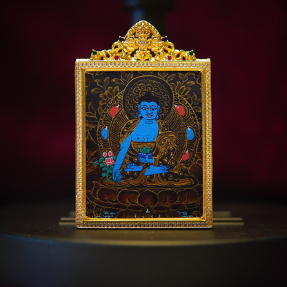 Hand-painted black gold Medicine Buddha pendant with intricate sapphire-blue design, featuring floral gold leaf details and Tibetan carvings.