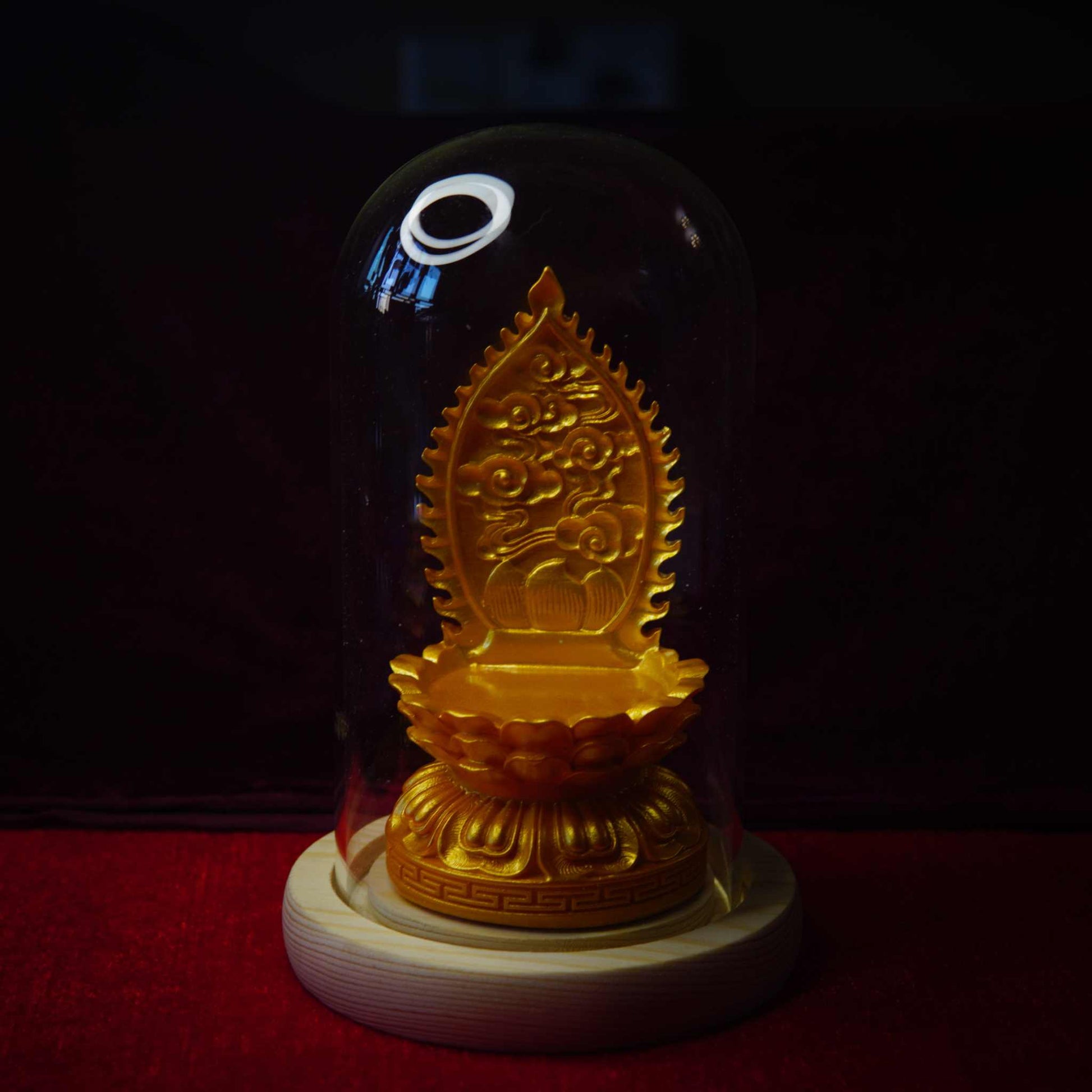 Thangka pendant display stand with golden lotus base under glass dome.