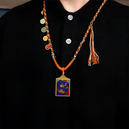 Mahakala Buddhist Pendant featuring fierce blue deity, skull crown, and golden flames on woven chain.