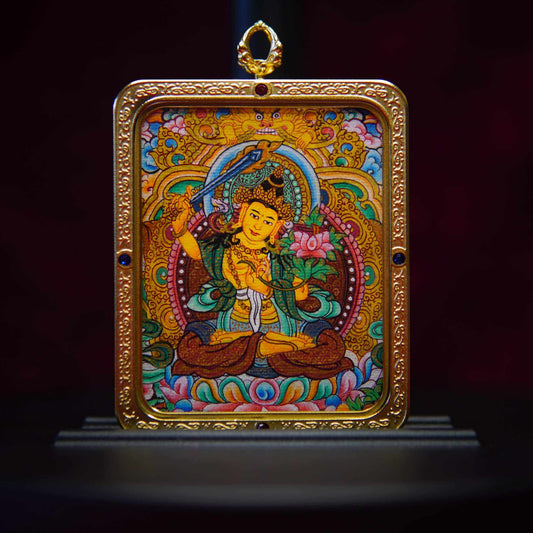 Hand-painted Tibetan Manjushri Wisdom Buddha pendant with ornate gold frame, depicting Bodhisattva in meditation.